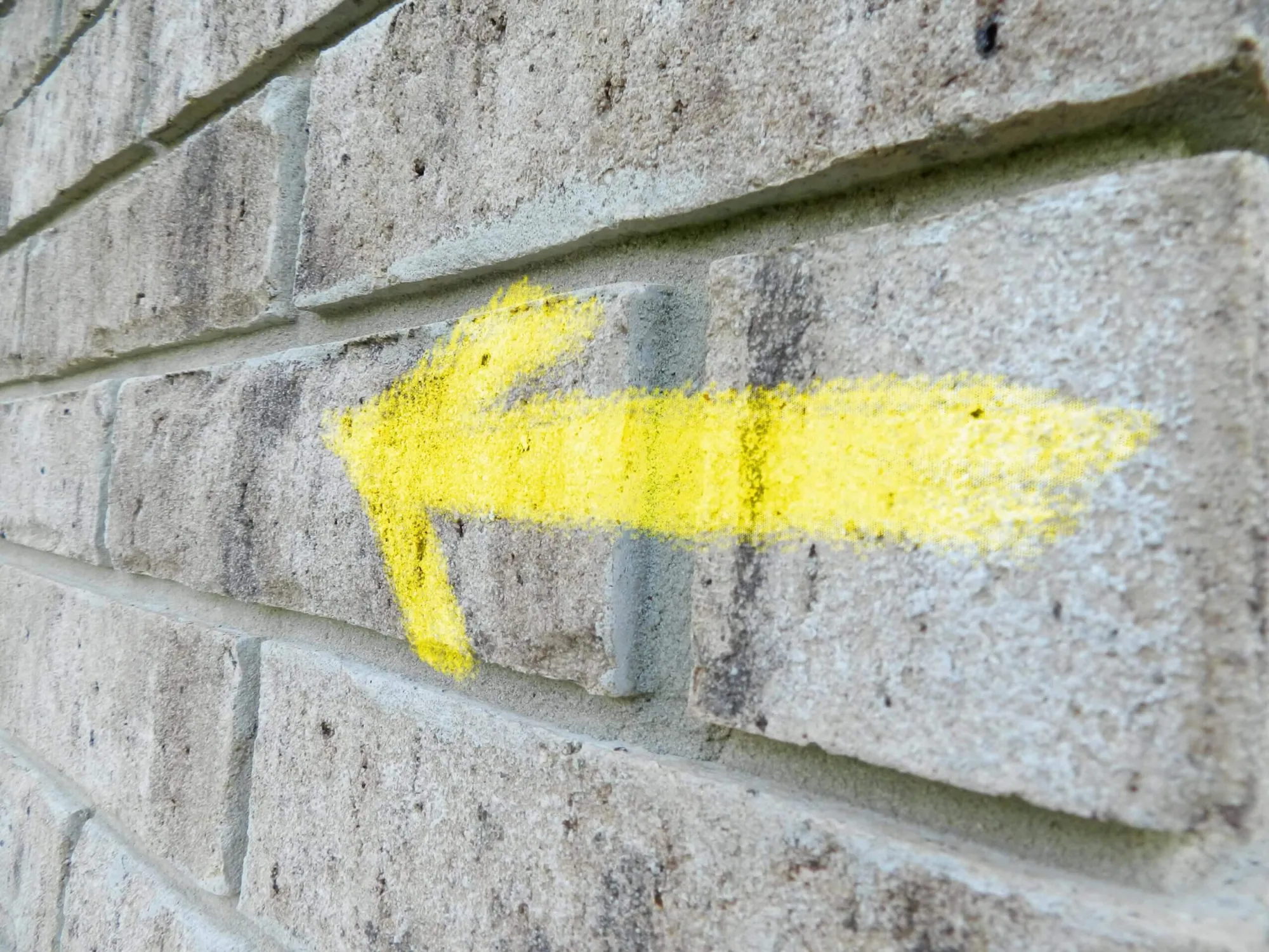 Arrow painted on brick wall