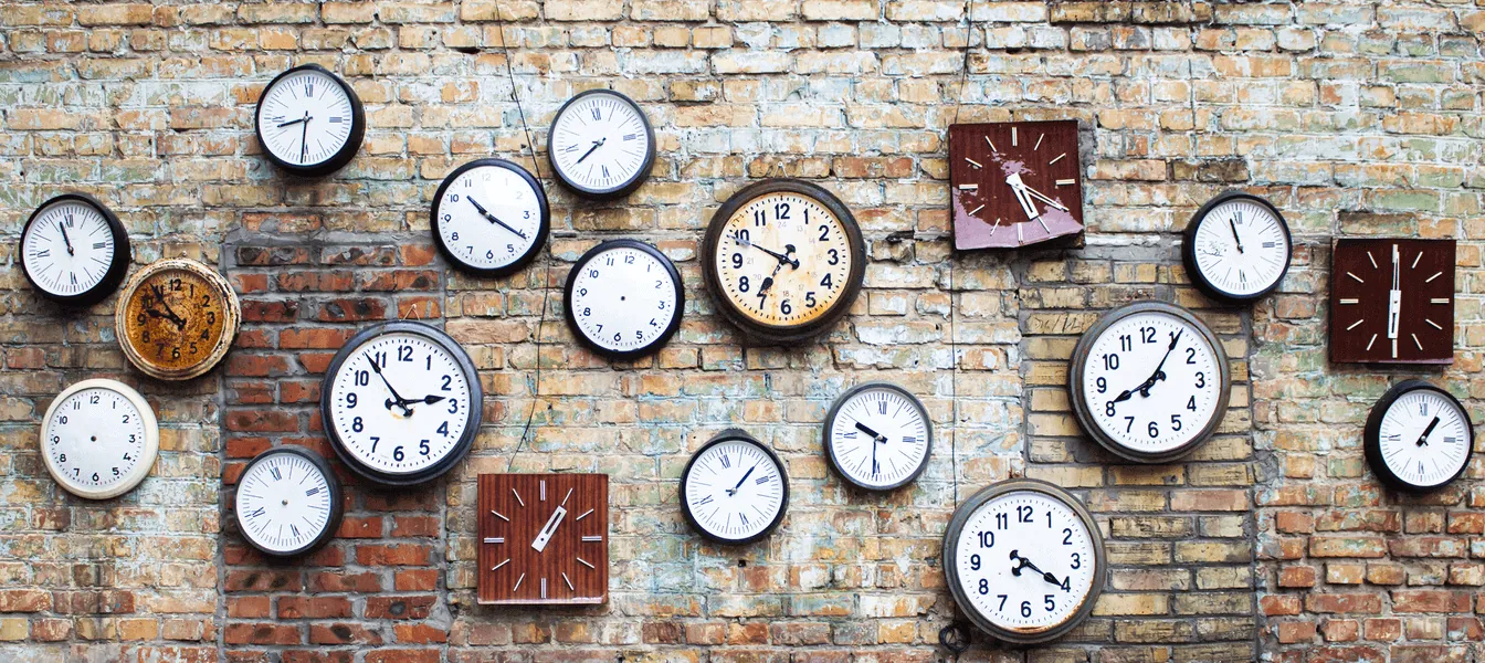 Multiple clocks on brick wall