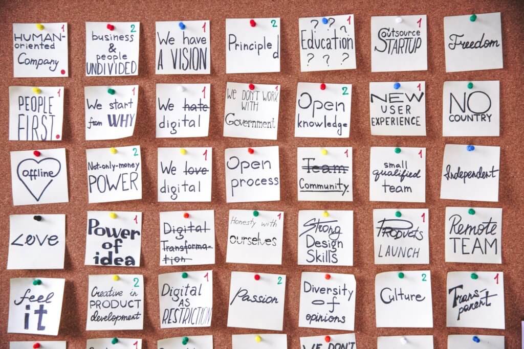 A cork board of pinned notes with words such as 'We have a vision', 'Open knowledge', 'Diversity of opinions' and 'Culture'